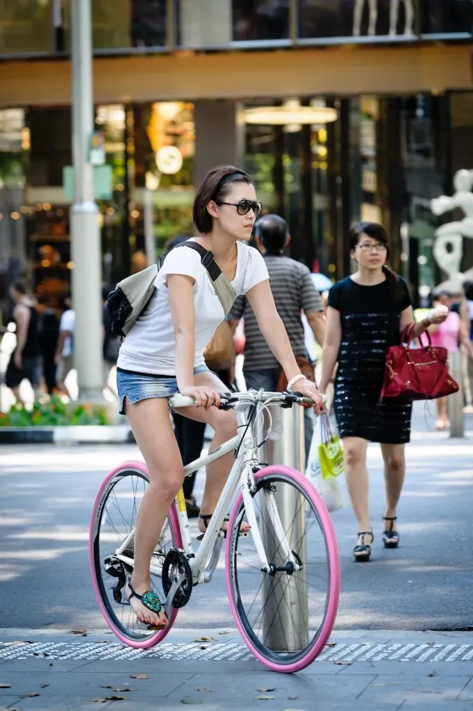 Girl riding a bicycle with pink tyres in Orchard Singapore