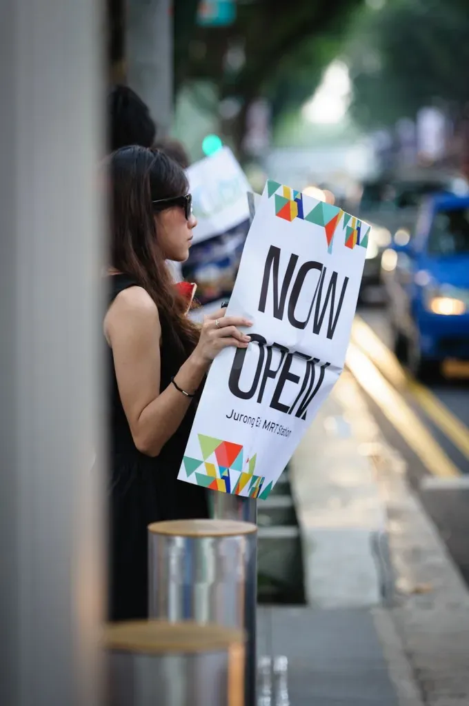 Girl holding newspaper that says "Now Open"