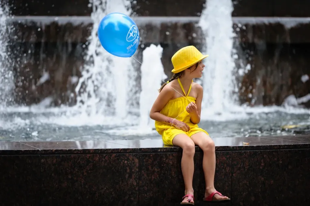 Girl in yellow with a blue balloon