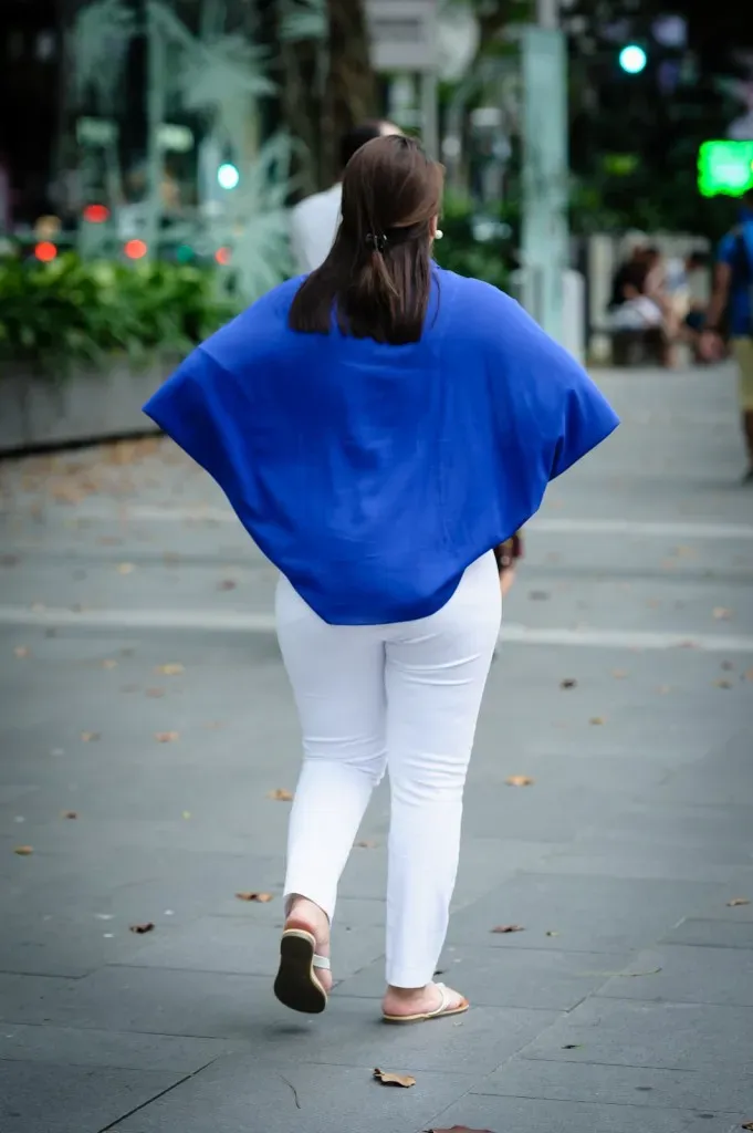 Woman in blue top and white pants