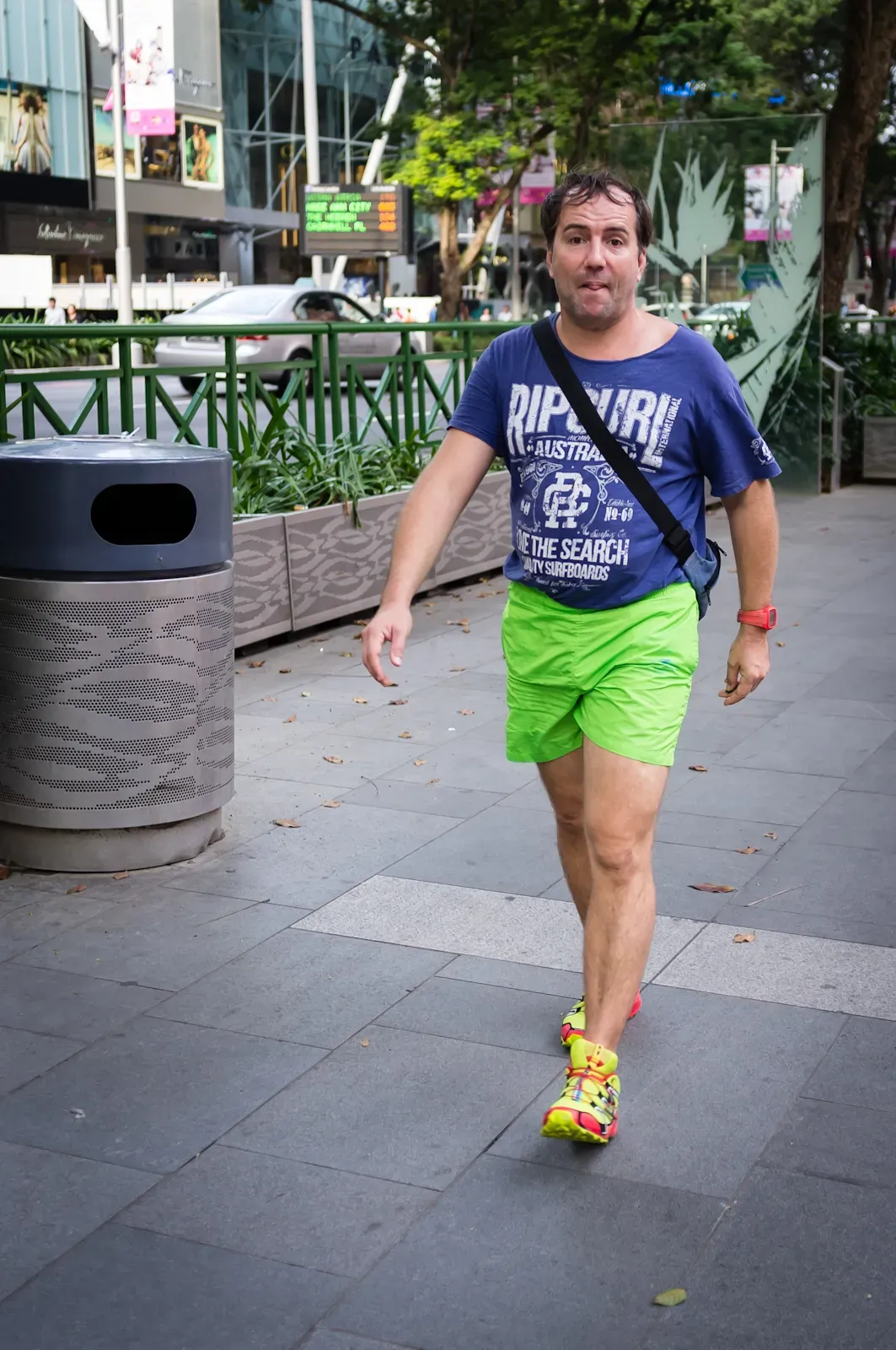 Tourist in blue top, green shorts and yellow shoes