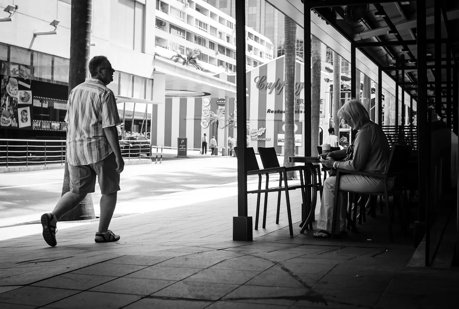 man walking past a woman in Starbucks