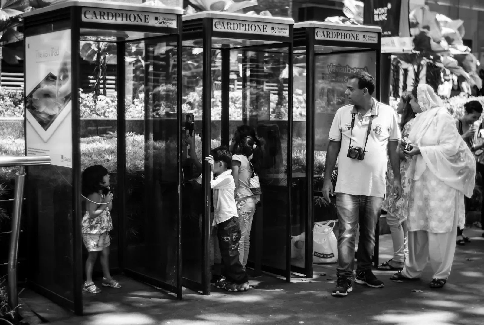 tourist family playing with a phone booth in Orchard Road