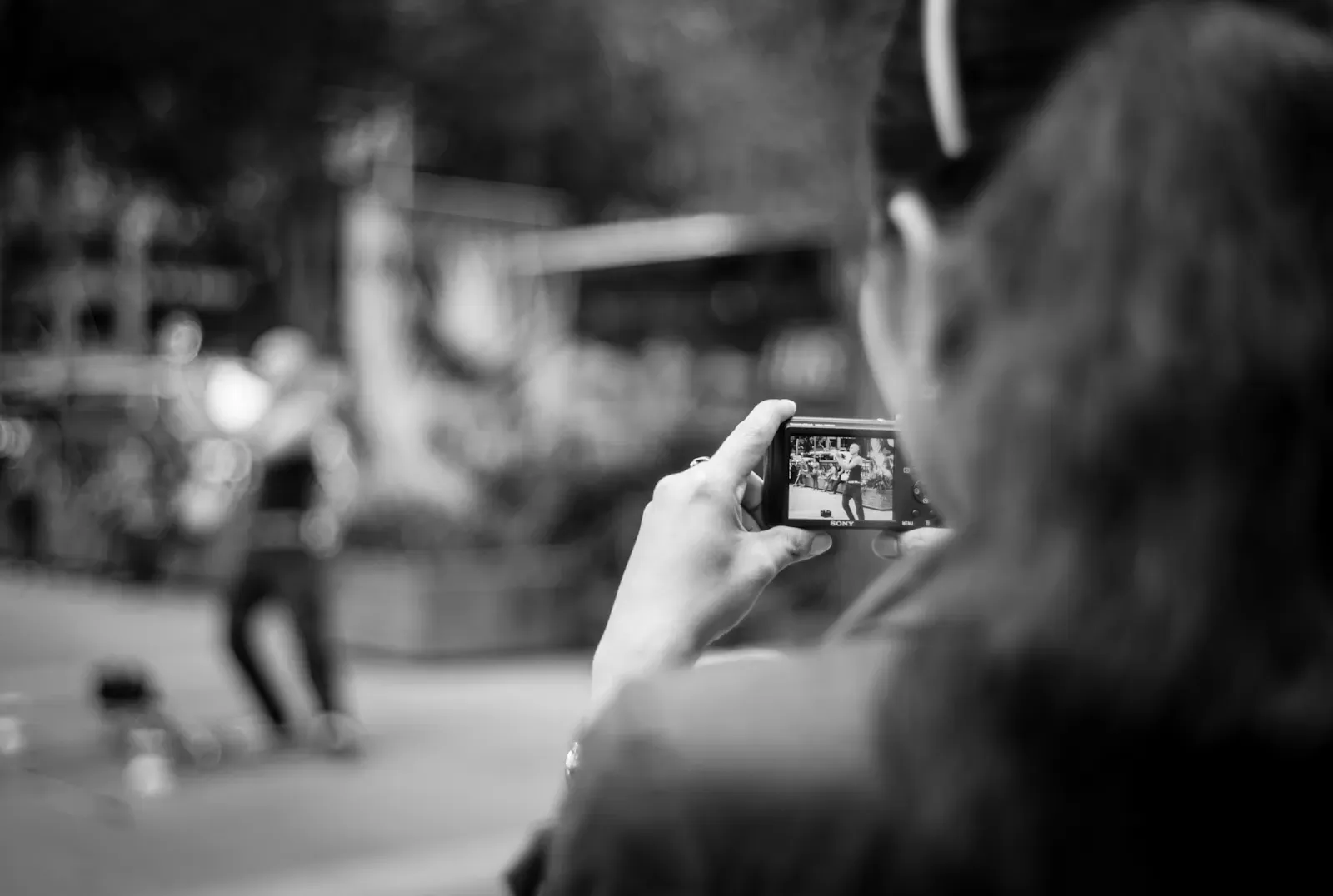 Woman recording a video of a street performer