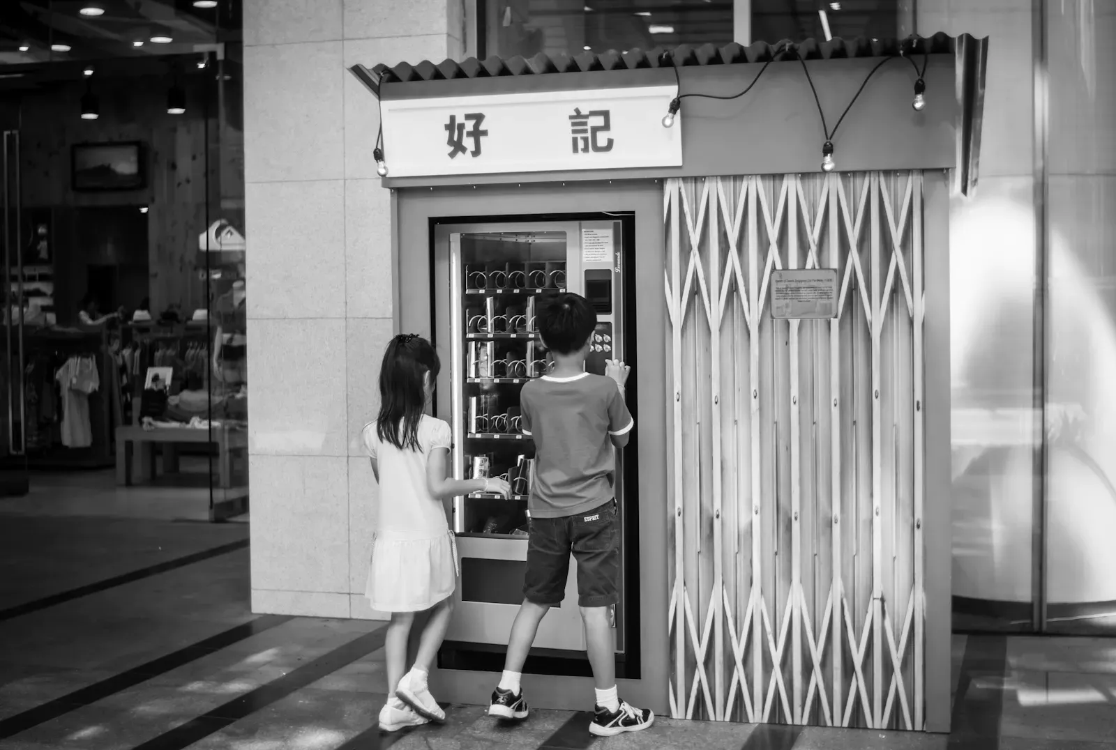 Two children playing with a snacks dispensing machine