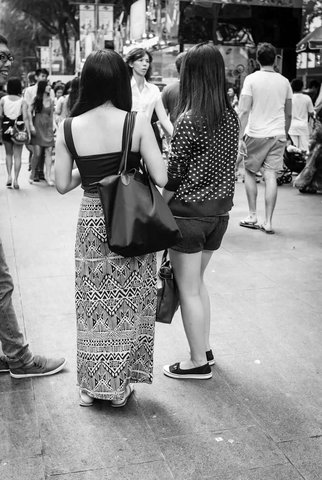 Girl in sleeveless top and long dress, and a girl in long-sleeved top and shorts