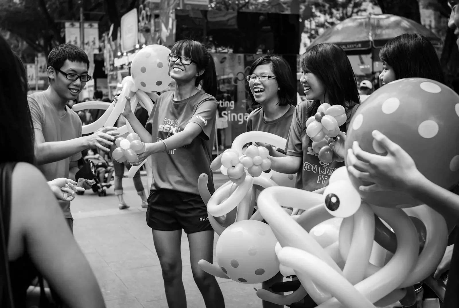 Boy buying a balloon sculpture from student volunteers