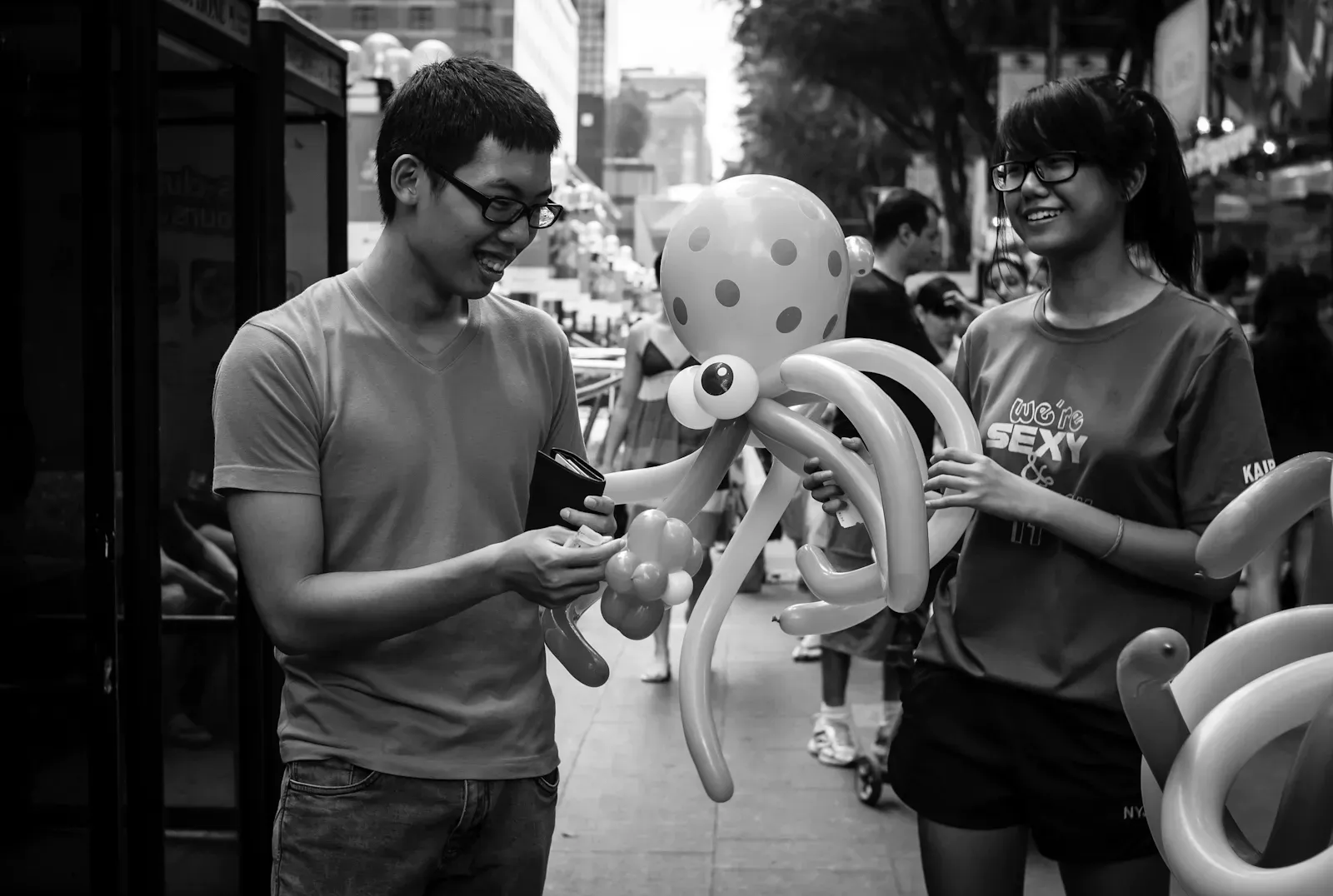 Boy buying a balloon sculpture from student volunteers