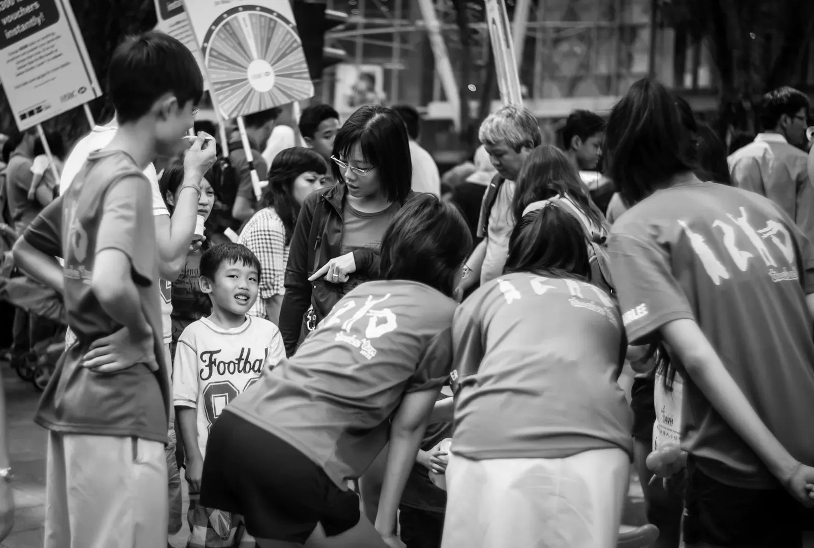 Woman buying a balloon sculpture from student volunteers for her son