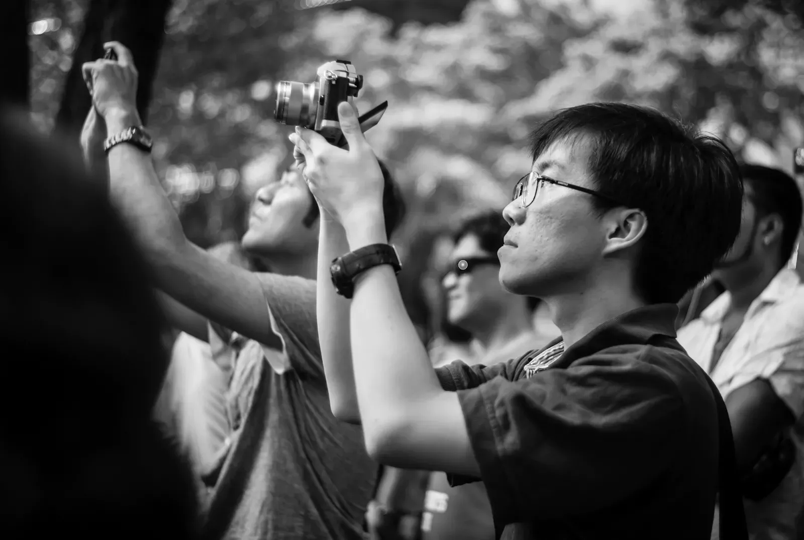 Photographer shooting over the crowd using the tilt-screen of the Olympus OM-D