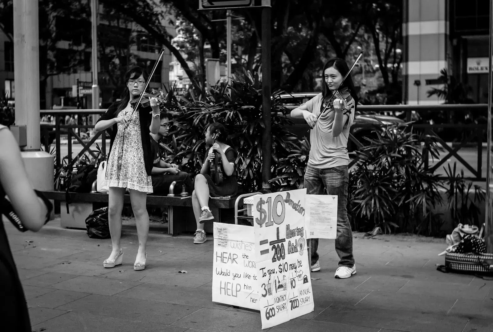 Violinists perform on the street to raise funds for the deaf