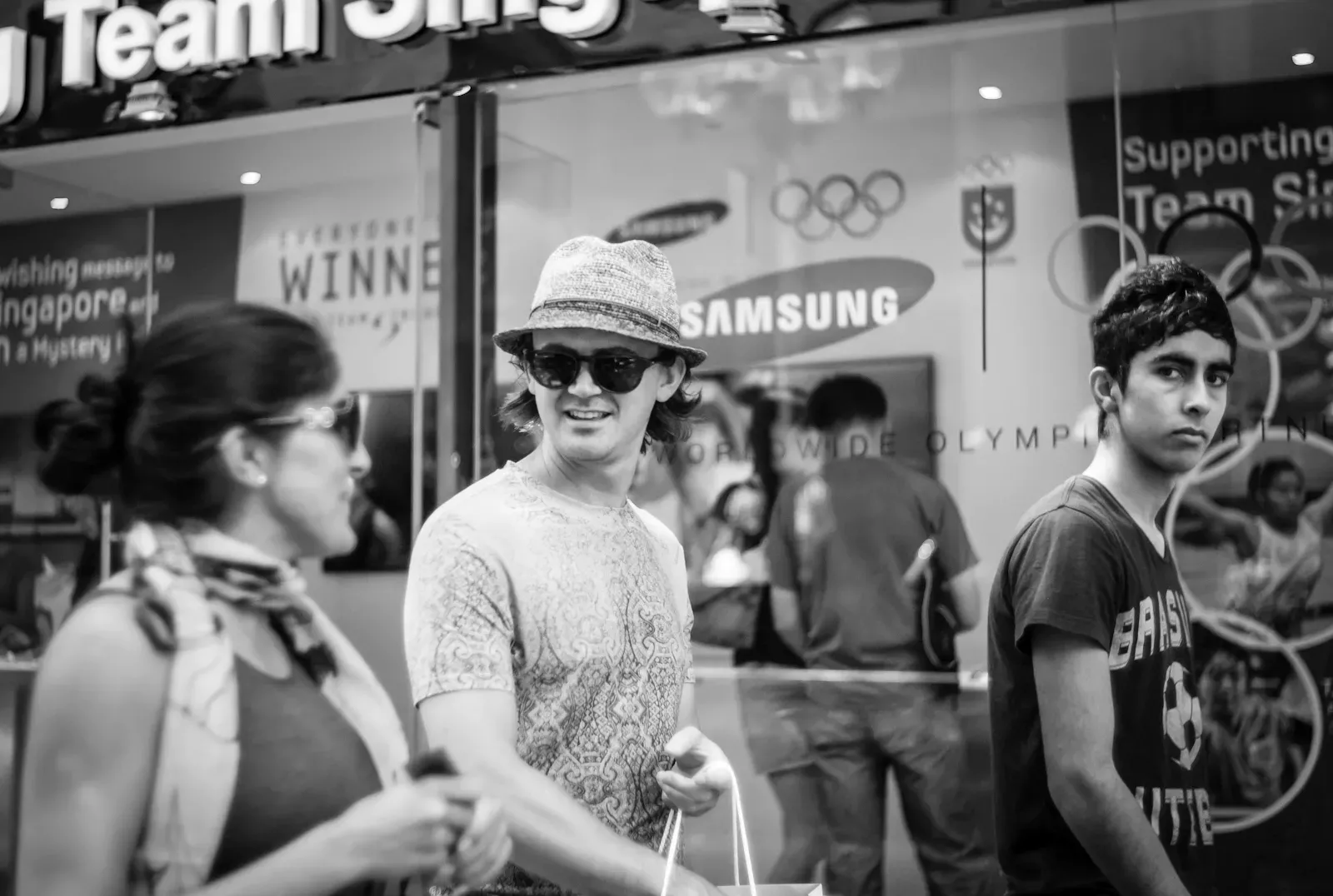 Three persons walking along Orchard Road