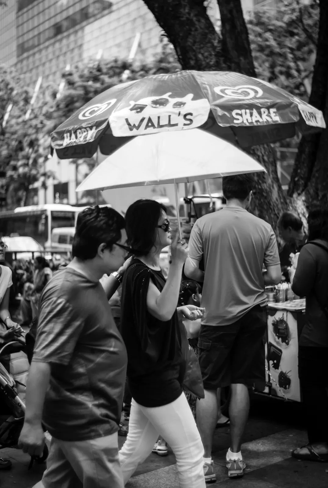 Two woman walking in Orchard Road under an umbrella